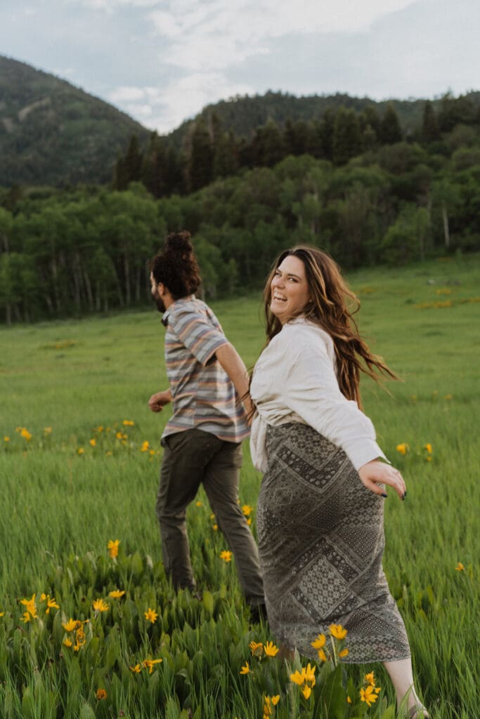 couple running through a field of flowers