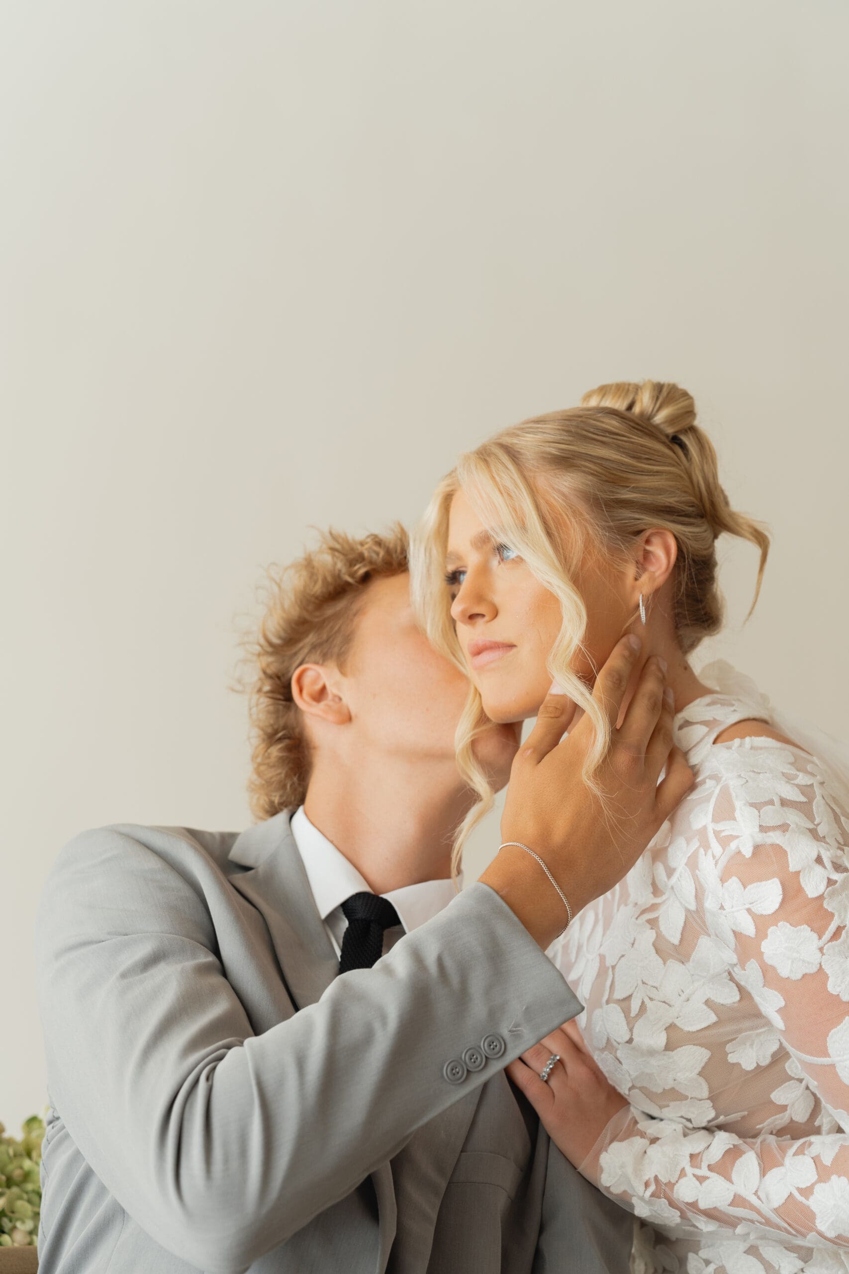 Bride and groom sharing a kiss inside a charming indoor space at one of the top wedding venues in Utah County.
