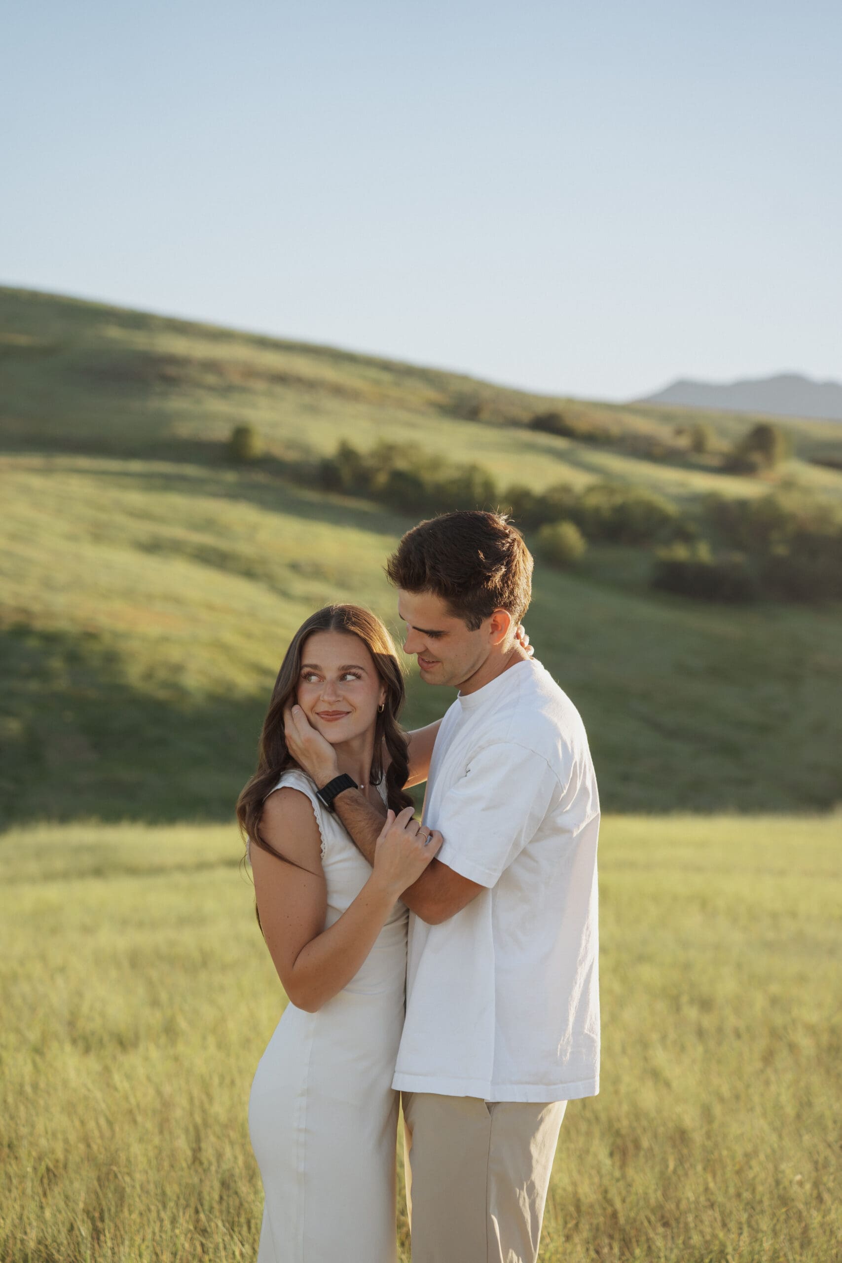 man holding girls cheek going in for a kiss