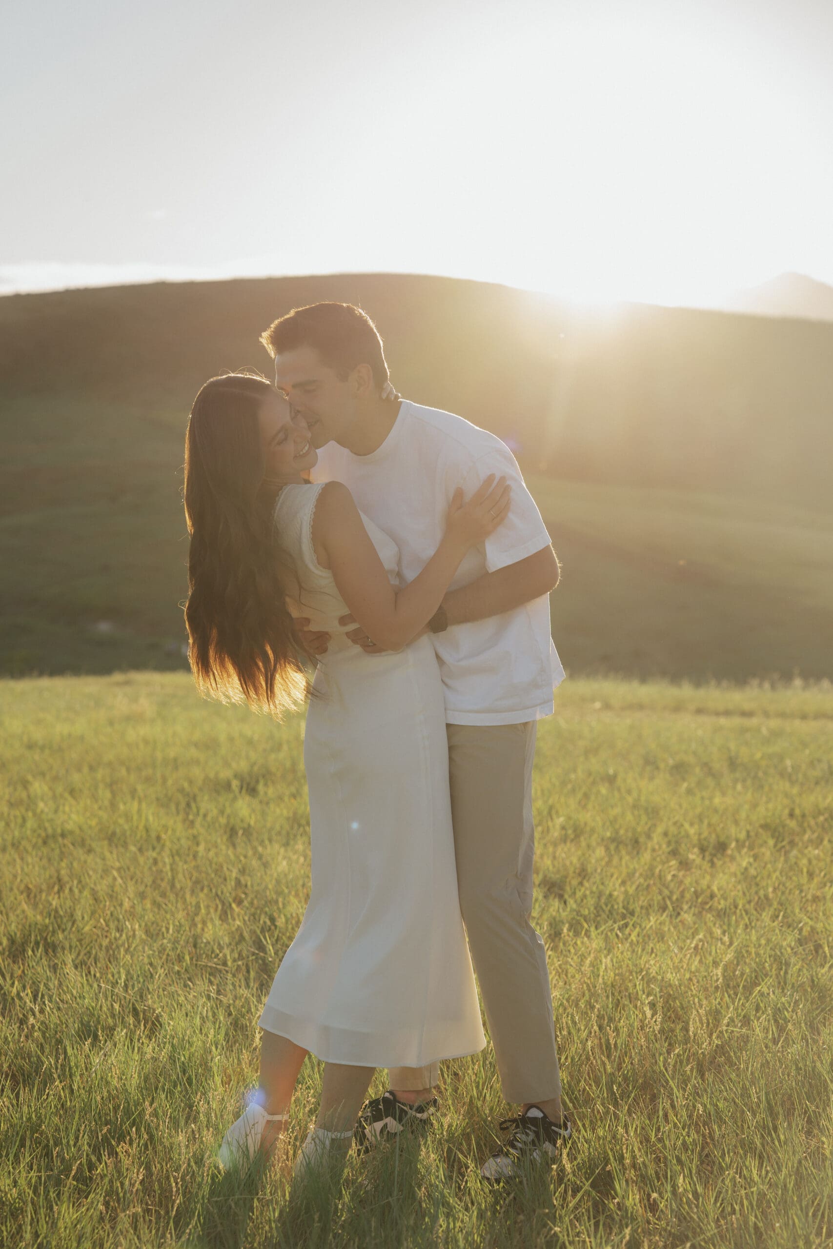 couple dancing in the golden light in a grassy field