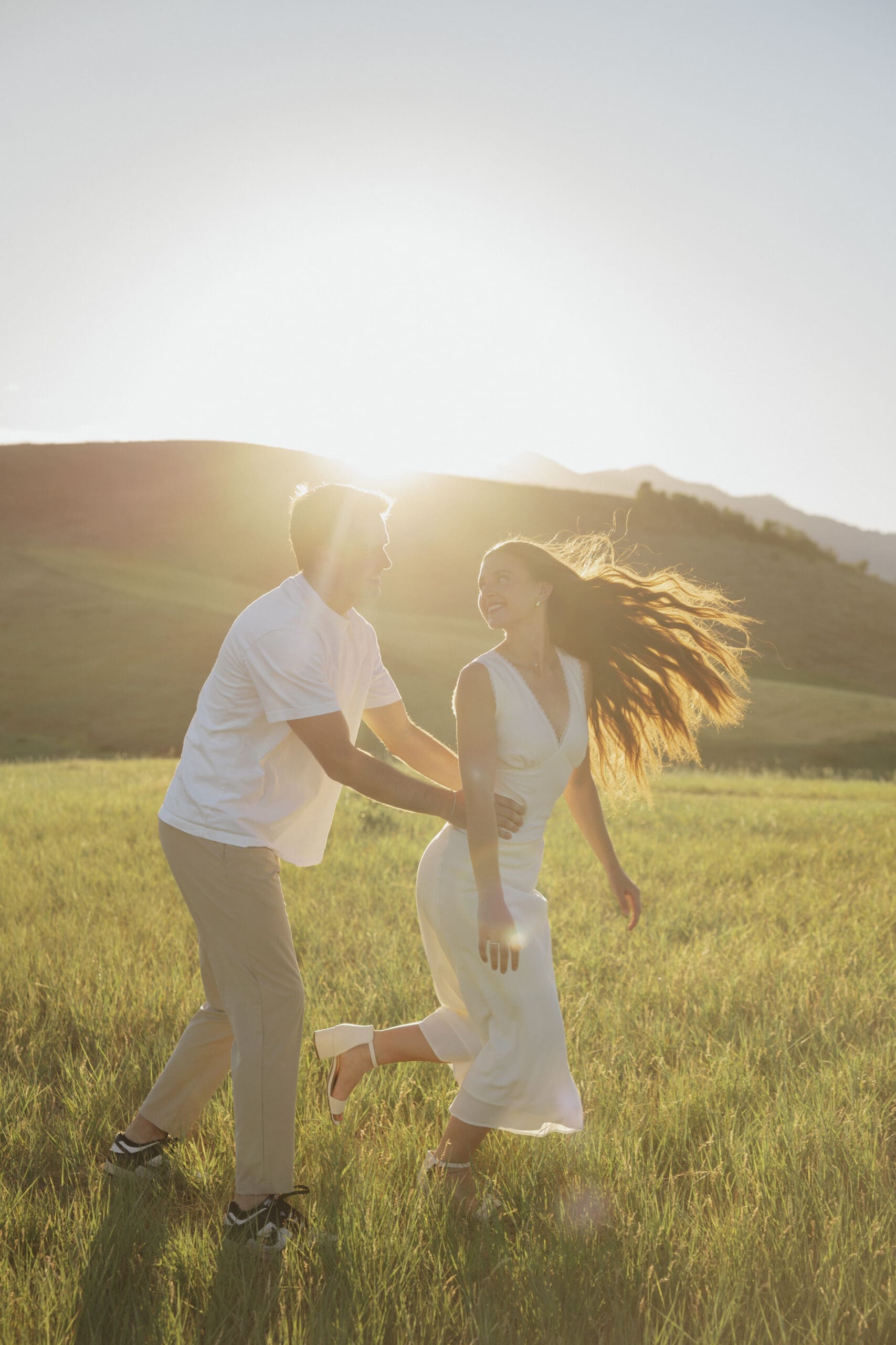 Playful engagement photo in a Cache Valley meadow