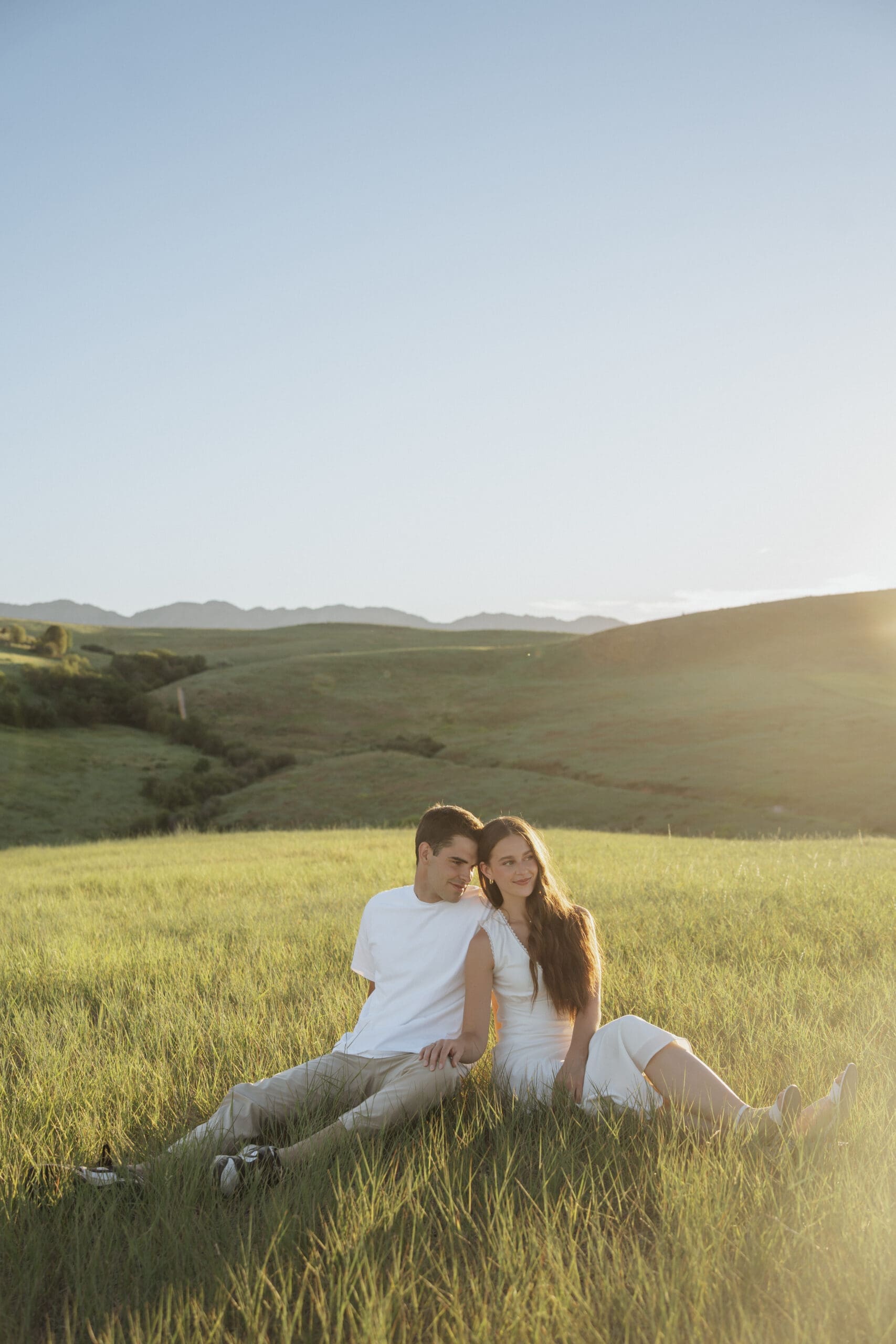 couple sitting side by side in a golden meadow in wellsville