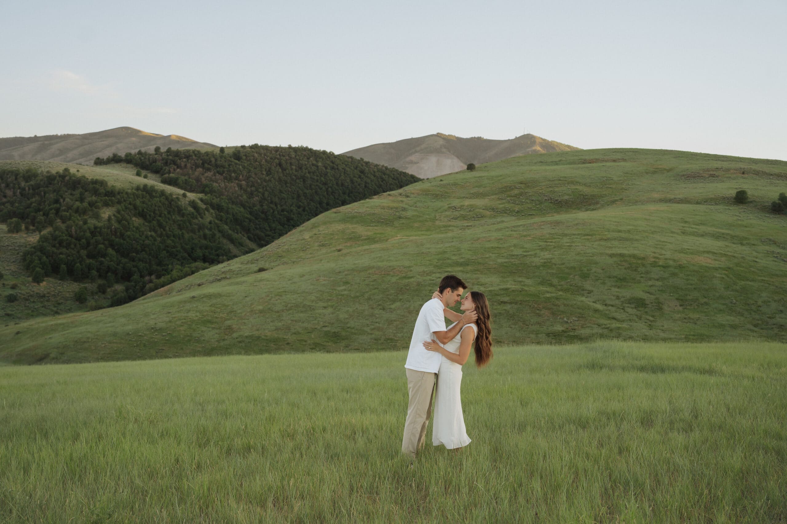 Cache Valley couple in a field holding one another