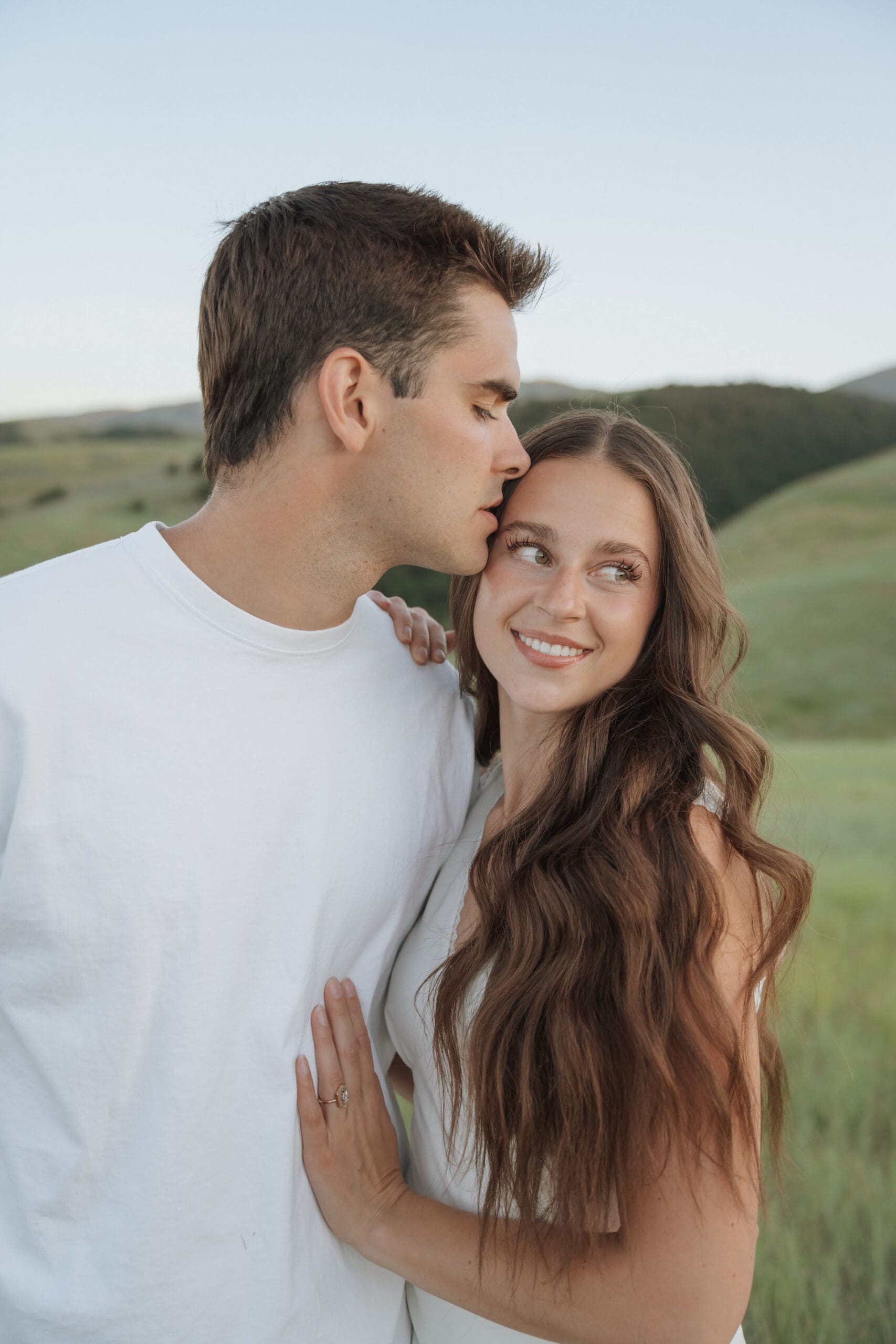 Couple twirling in a green meadow during their Wellsville Utah engagement session