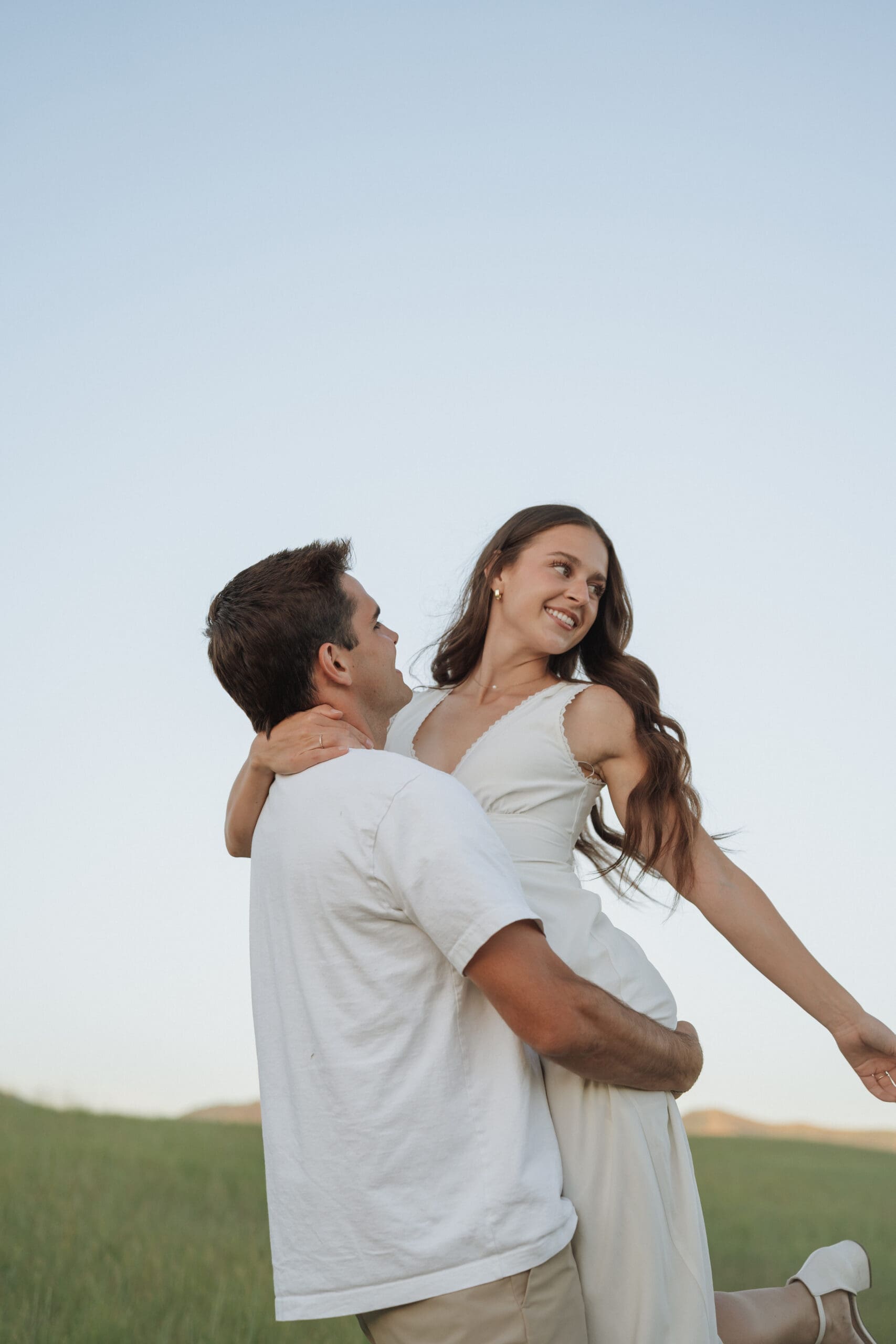 man holding his wife in the blue sky