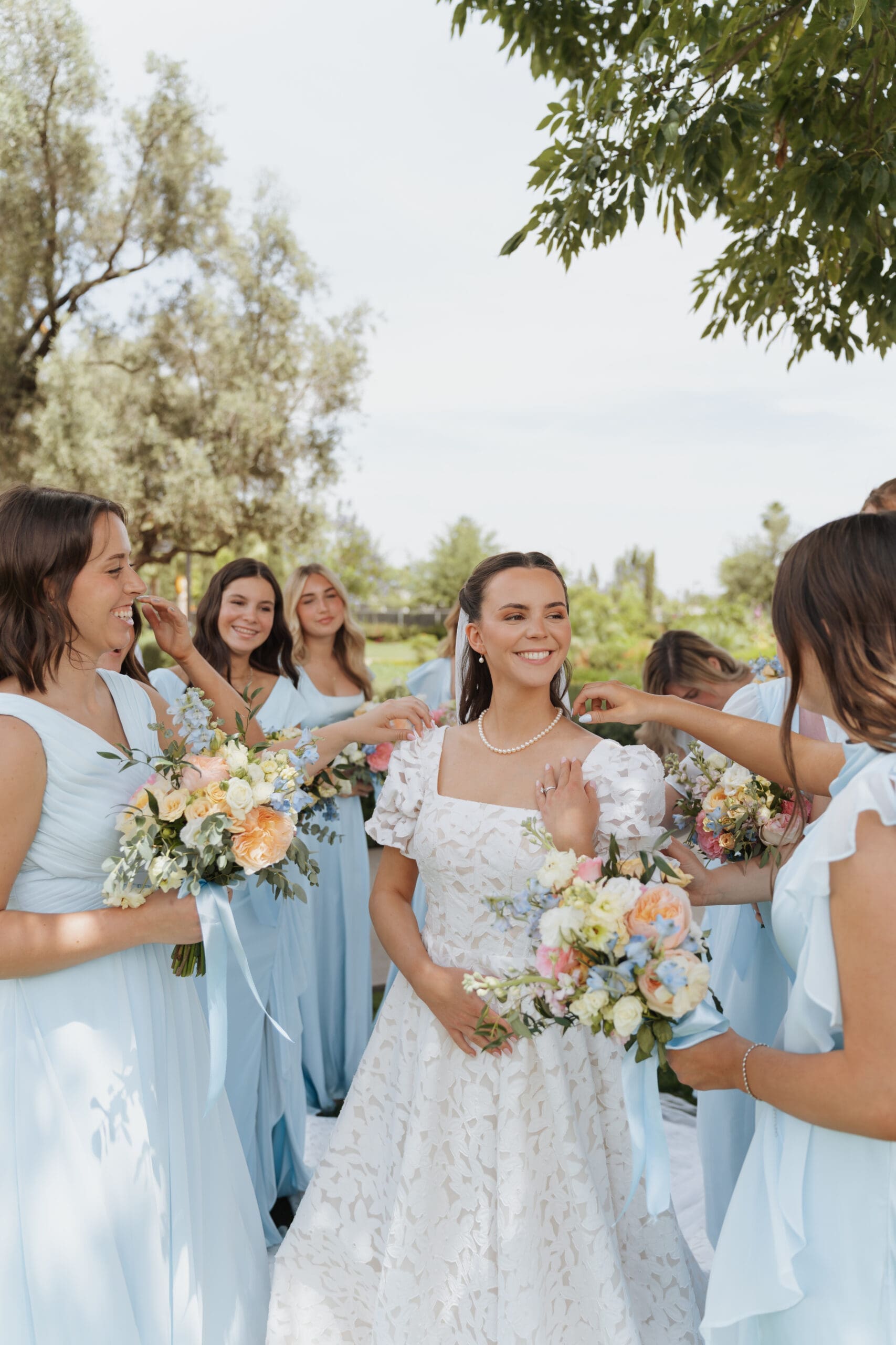 brides maids fixing brides dress