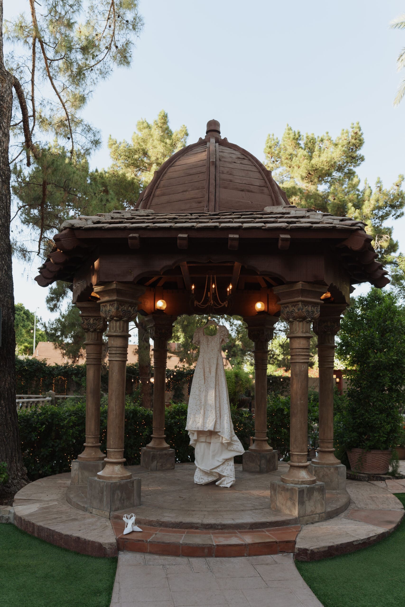 wedding dress hung up under a gazebo